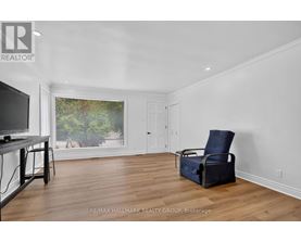 A living room with a television, chair, and window view.
