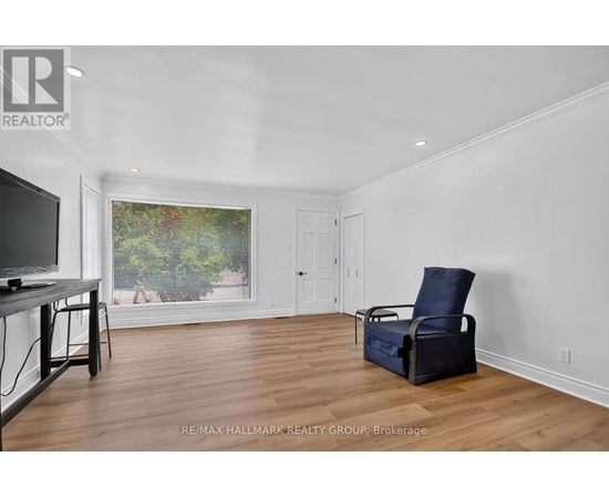 A living room with a television, chair, and window view.