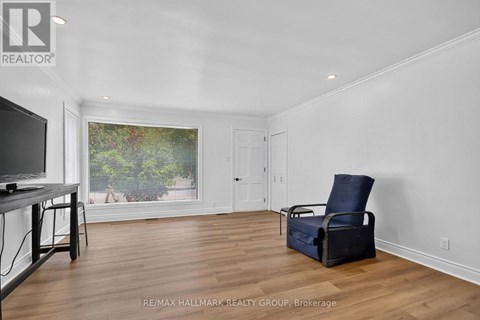 A living room with a television, chair, and window view.