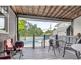 A patio with a table, chairs, and a pool in the background.