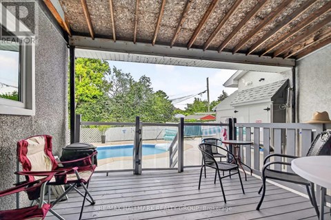 A patio with a table, chairs, and a pool in the background.