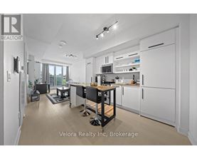 A modern kitchen with white cabinets and a black island.