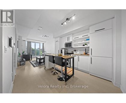 A modern kitchen with white cabinets and a black island.