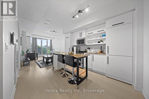 A modern kitchen with white cabinets and a black island.
