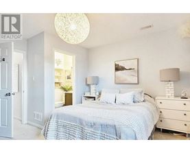 A bedroom with a bed, dresser, and lamp.