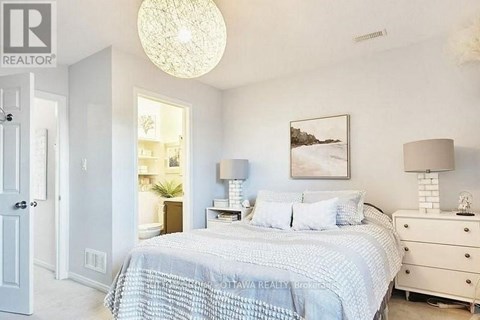 A bedroom with a bed, dresser, and lamp.