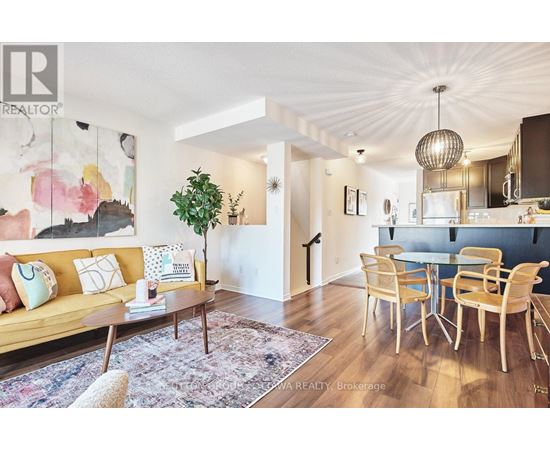 A living room with a yellow couch and a dining table with chairs.