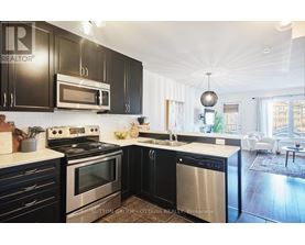 A modern kitchen with black cabinets and stainless steel appliances.