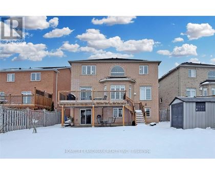 A real estate photo of a house with a snowy front yard.
