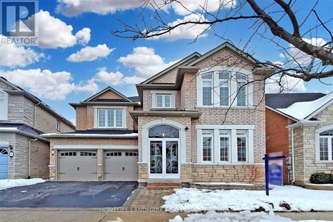 A large brick house with a blue sign in front.