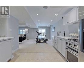A modern kitchen with a stove top oven and a vacuum cleaner in the middle of the room.