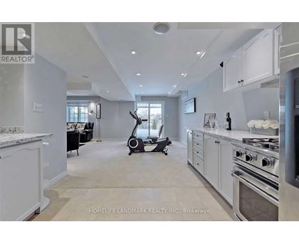 A modern kitchen with a stove top oven and a vacuum cleaner in the middle of the room.