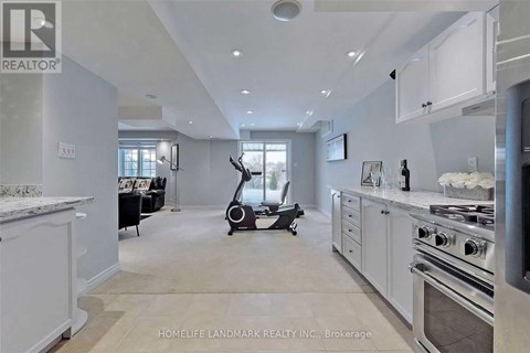 A modern kitchen with a stove top oven and a vacuum cleaner in the middle of the room.