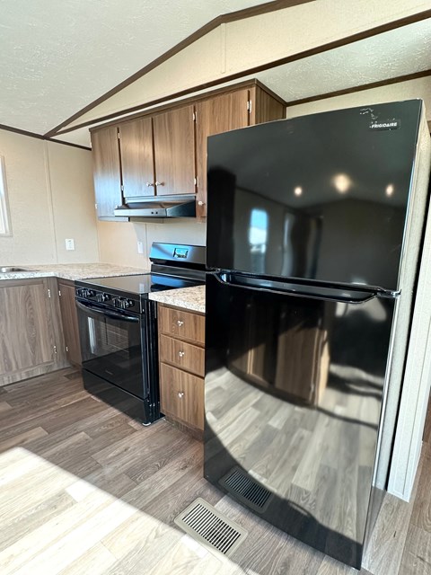 A black stove and oven in a kitchen with wooden cabinets.