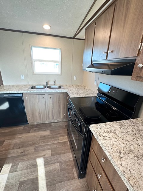 A kitchen with wooden cabinets and black appliances.