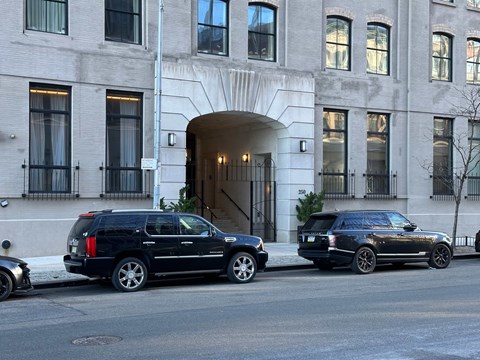 Two black SUVs parked in front of a building.
