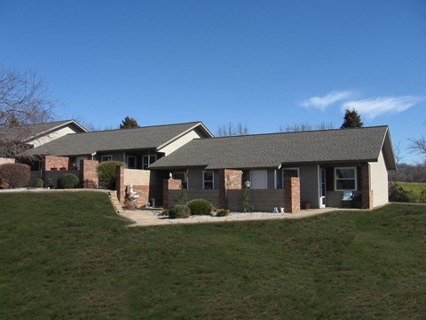 A house with a grey roof and a green lawn in front.