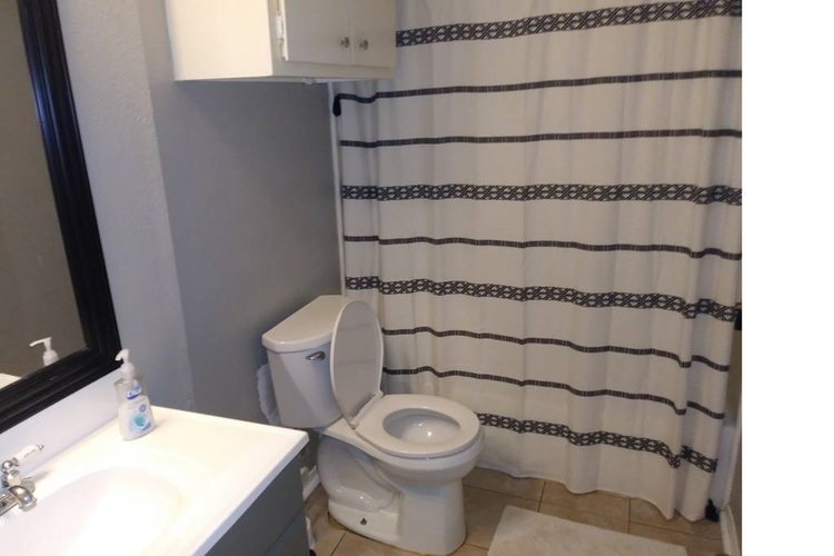 A white toilet sits next to a sink in a bathroom.