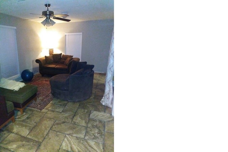 A living room with a couch, chair, and a fan.