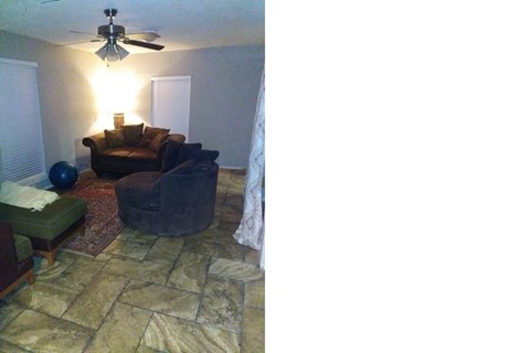 A living room with a couch, chair, and a fan.