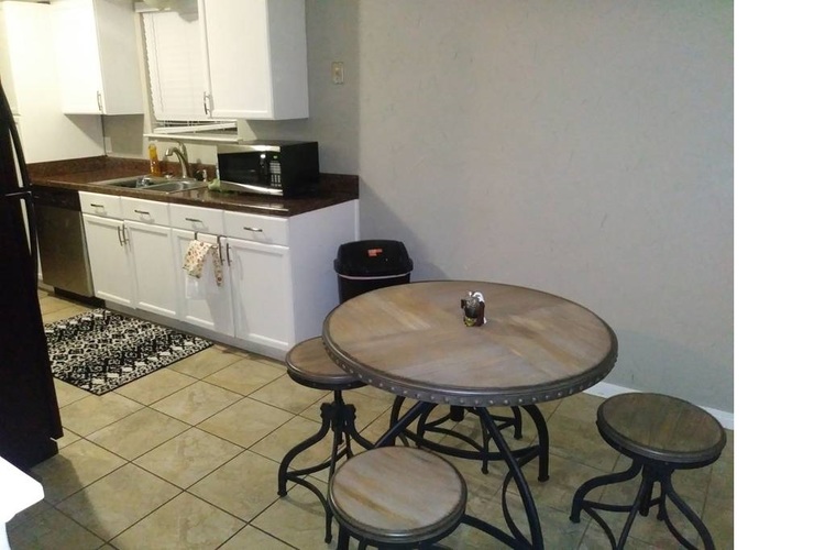 A kitchen with a table and stools.