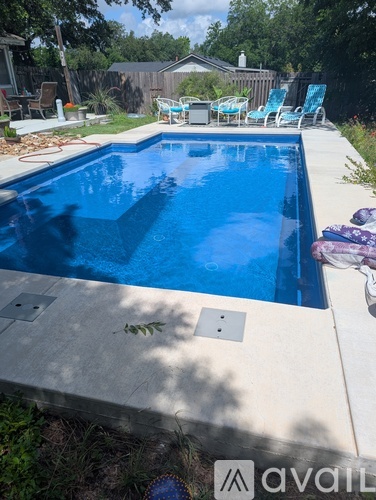 A pool with a blue tiled edge and a white tiled floor.