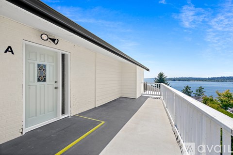 A white building with a blue door and a balcony with a railing.