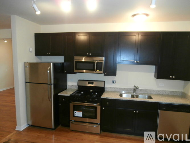 A kitchen with black cabinets and stainless steel appliances.