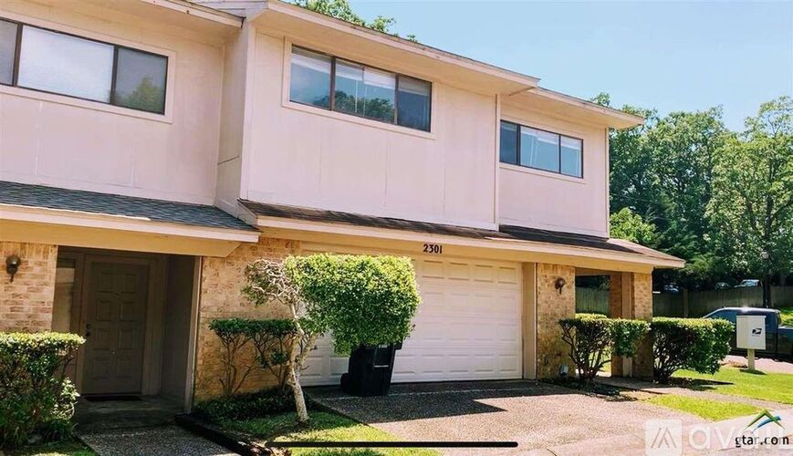 A two-story house with a garage and a driveway.