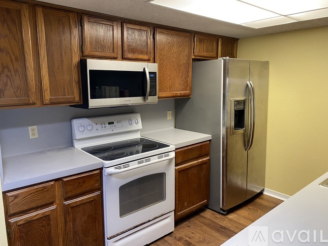 A kitchen with a stove, microwave, and refrigerator.