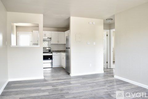 A kitchen with white cabinets and a grey floor.