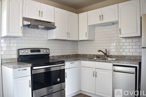 A kitchen with white cabinets and a black stove top oven.