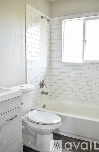 A white toilet sits next to a bathtub in a bathroom.