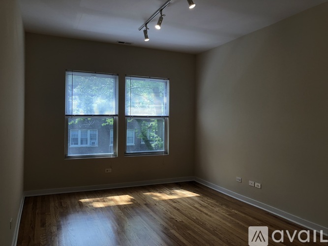 A room with wooden floors and two windows.
