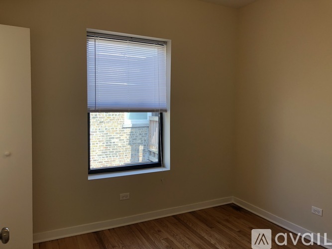 A room with a window and wooden flooring is available for rent.