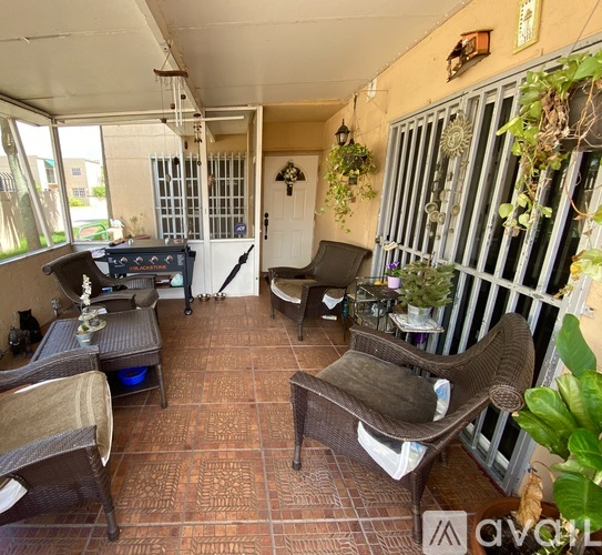 A patio with a table, chairs, and a grill.