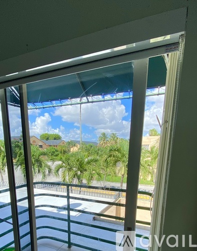A balcony with a view of the sky and palm trees.