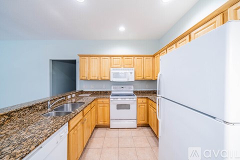 A kitchen with wooden cabinets and a granite countertop.