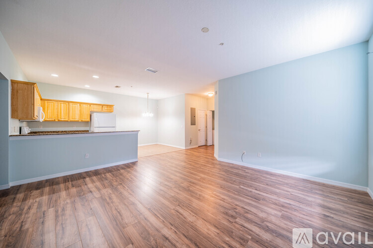 A spacious room with wooden flooring and white walls.