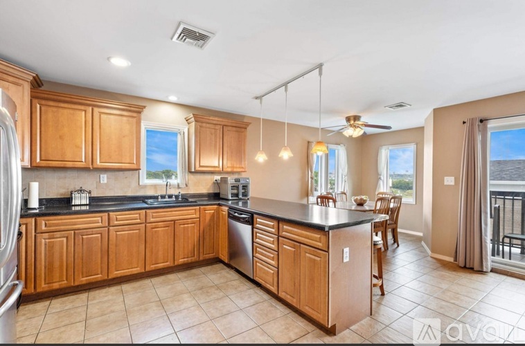 A kitchen with wooden cabinets and a black countertop.