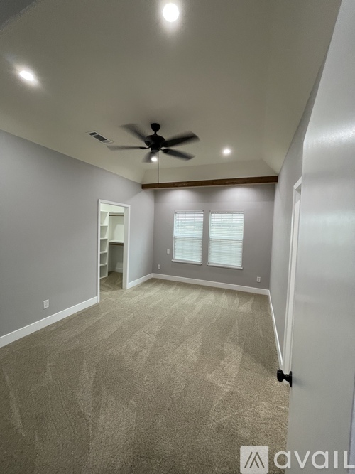 A room with a ceiling fan and carpeted floor.