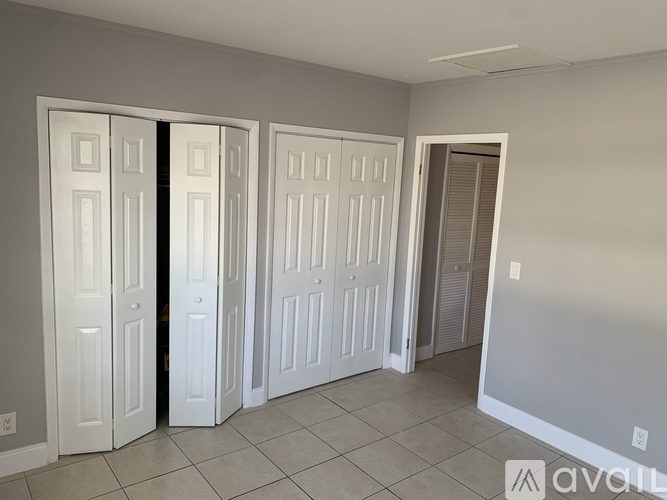 A room with three white doors and a tiled floor.