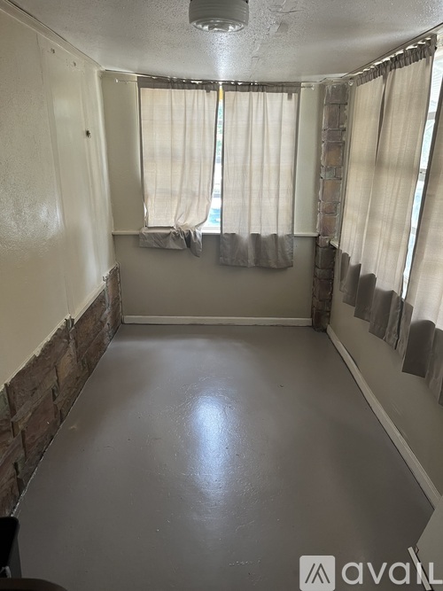 A room with a window and curtains.