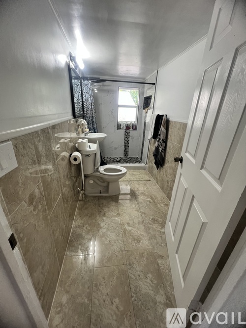 A bathroom with a toilet, sink, and mirror.
