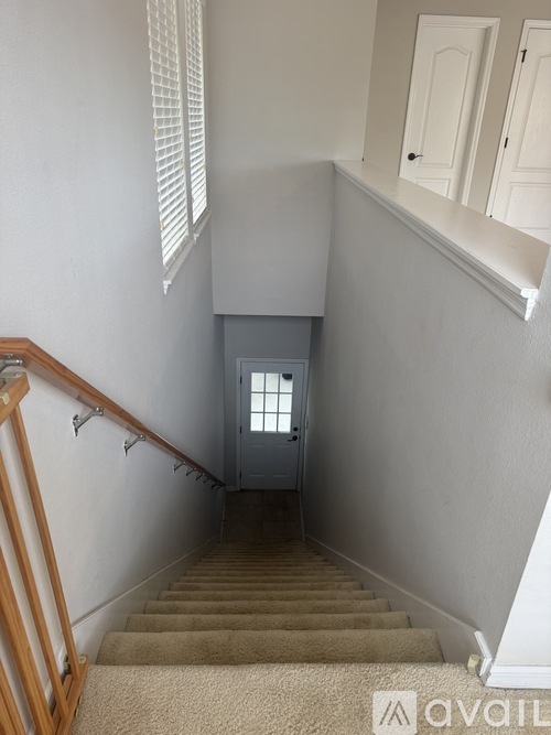 A staircase with a carpeted runner and wooden banister.