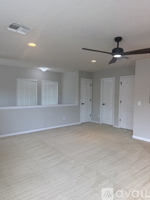 A room with a ceiling fan and light fixture.