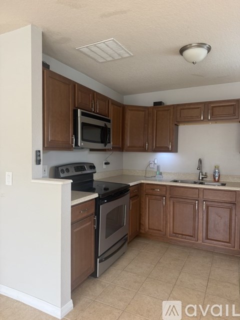 A kitchen with brown cabinets and a black stove top oven.