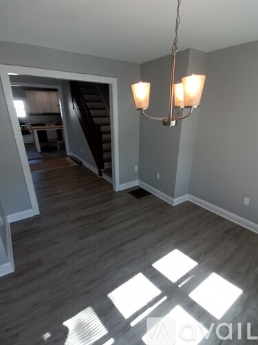 A living room with a chandelier and a staircase.