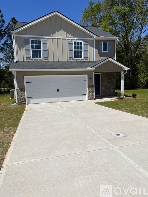 A two-story house with a garage and a driveway.