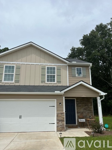 A house with a garage and a sign that says "avail".